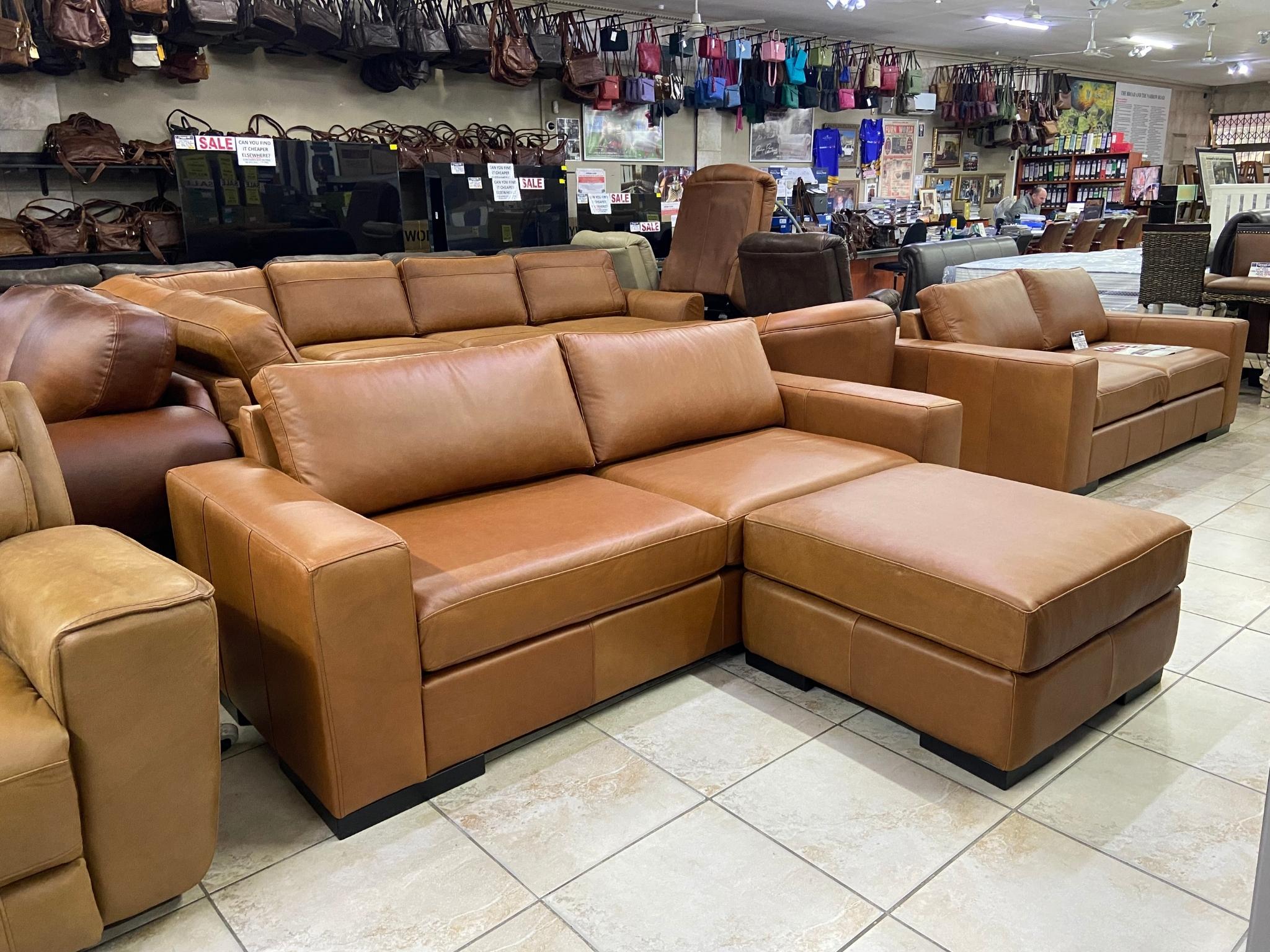 Impala tan genuine leather sofa and matching ottoman displayed in the Furnworld showroom