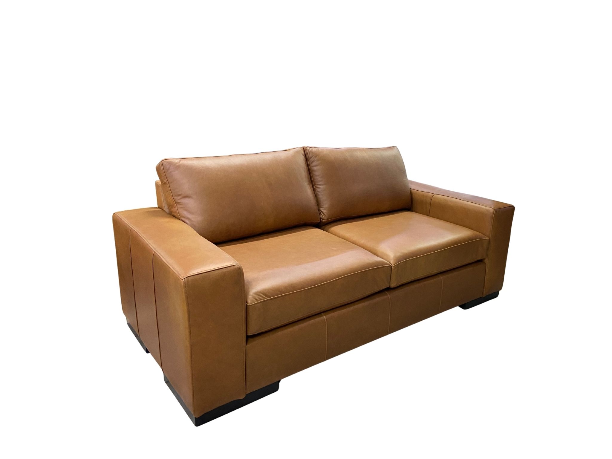 Angled view of the Impala rustic tan leather sofa showing seat cushions and stitched arms